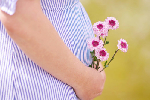 Pregnant woman holding wild flowers